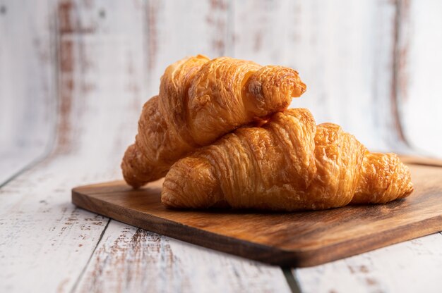 Croissants on a wooden cutting board.