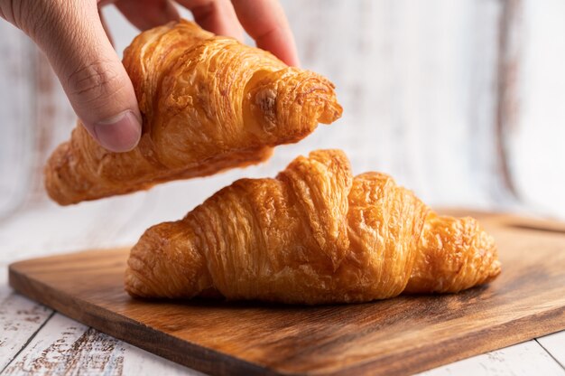 Croissants on a wooden cutting board.