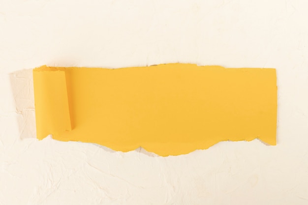 Free photo crooked yellow strip of paper on a pale rose background