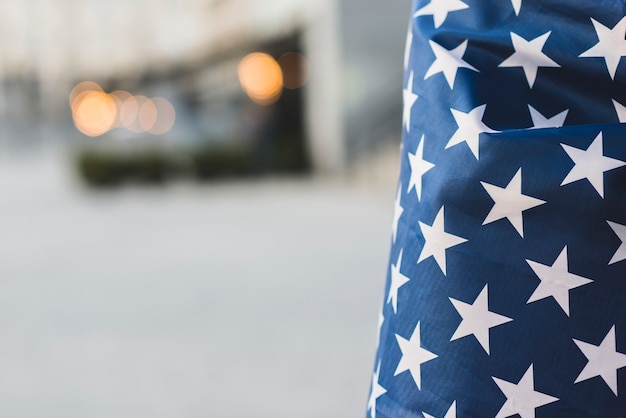 Crop American flag with wrapped person