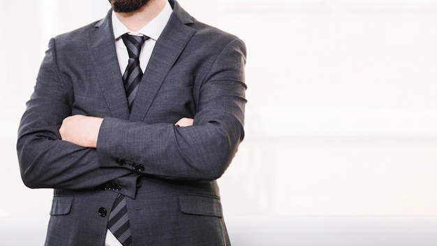 Crop businessman with arms crossed