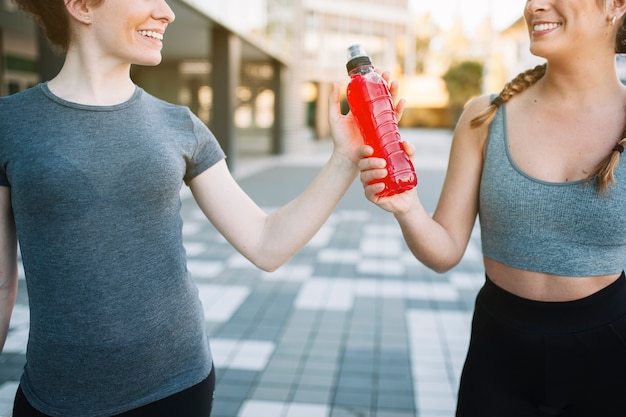 Free photo crop cheerful fit women with red drink