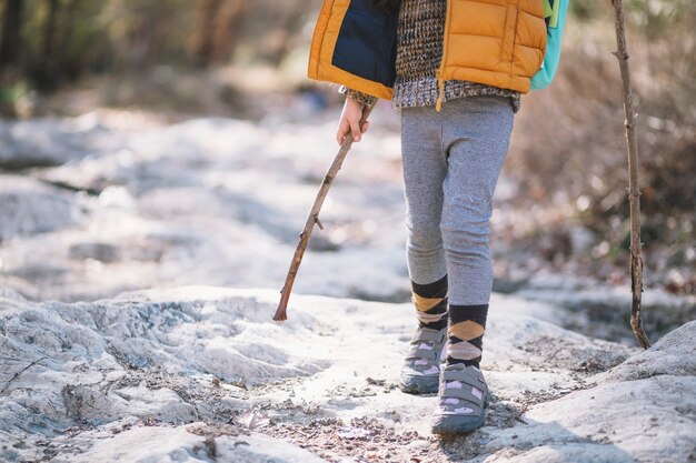 Crop child hiking in woods