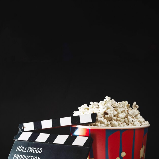 Crop clapperboard and popcorn bucket