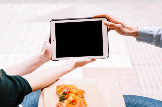 Crop couple hands holding tablet