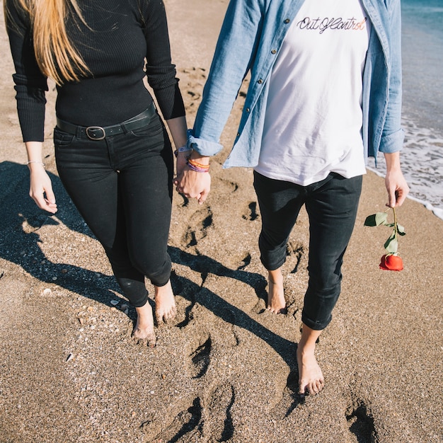 Free photo crop couple in love walking on beach