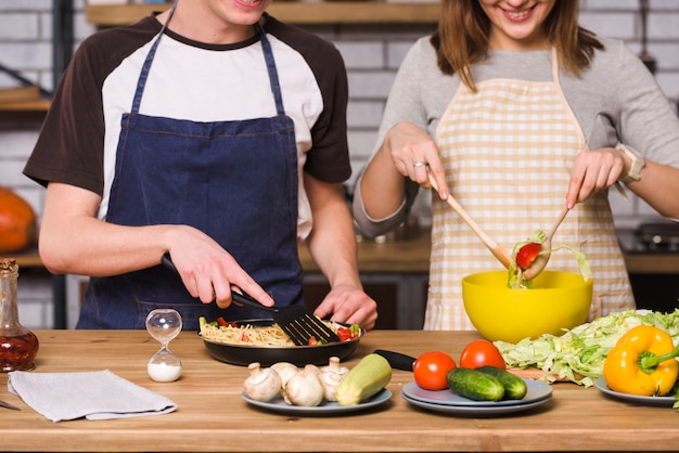 Free photo crop couple mixing vegetables