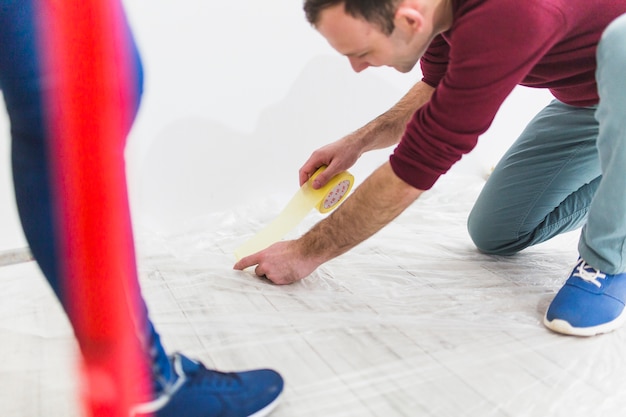 Crop couple protecting floor with sheet