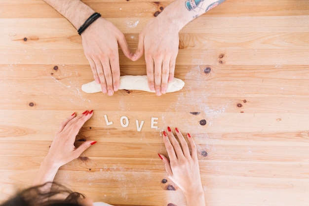 Free photo crop couple rolling dough