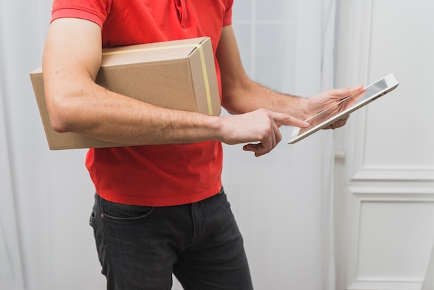 Crop courier with parcel and tablet