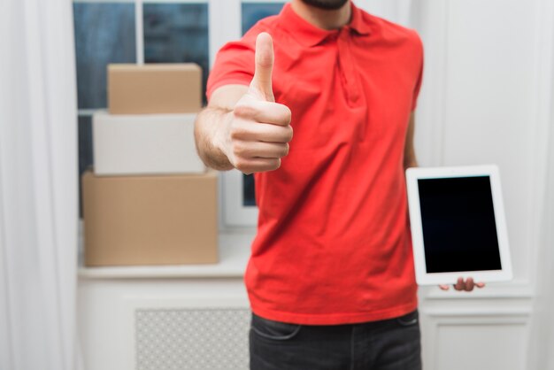 Crop courier with tablet gesturing thumb-up