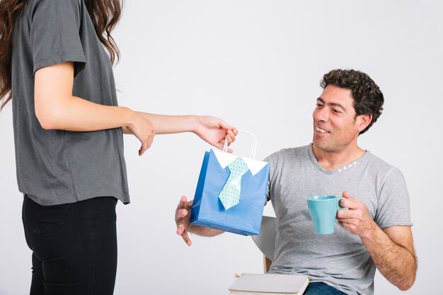 Crop daughter giving present to dad