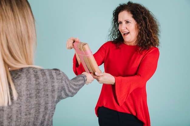 Crop daughter giving present to mother