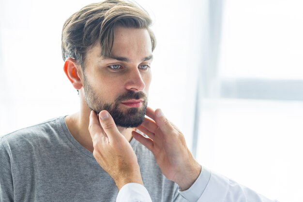 Crop doctor touching lymph nodes of young man