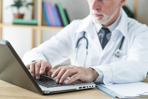 Free photo crop doctor typing on laptop