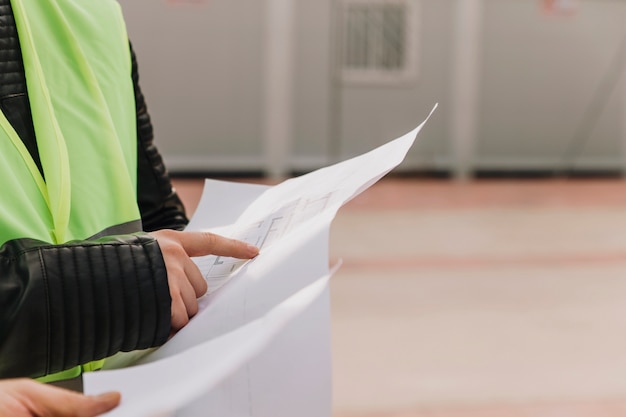 Crop draftsmen pointing at blueprints