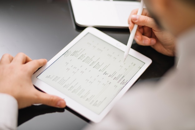 Crop employee with tablet and pencil