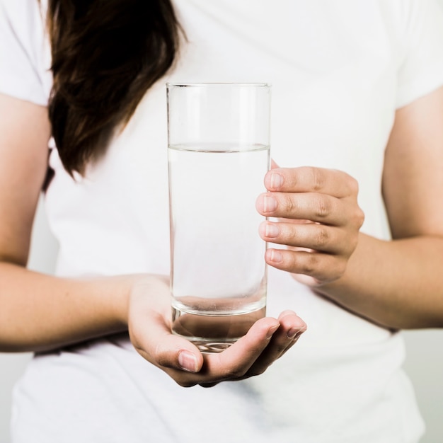 女性の手を水のガラスを保持する