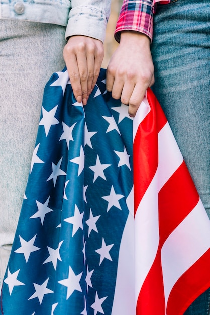 Crop female hands with colorful USA flag