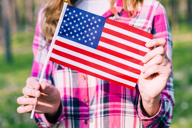 Crop female holding flag of United States