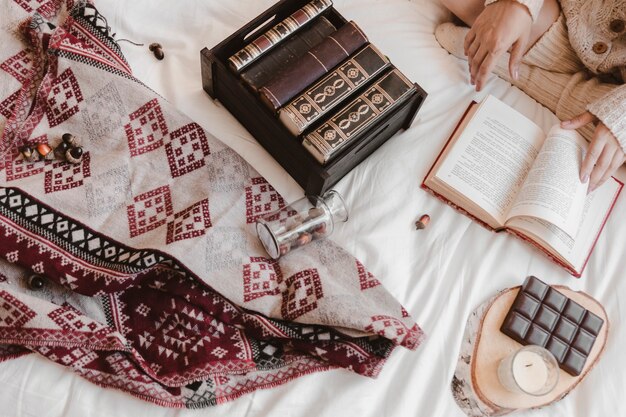 crop female reading on bed