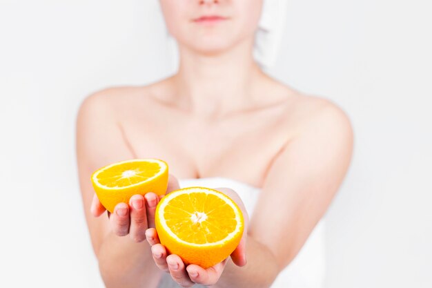 Обрезать женщин в полотенце с оранжевыми ломтиками