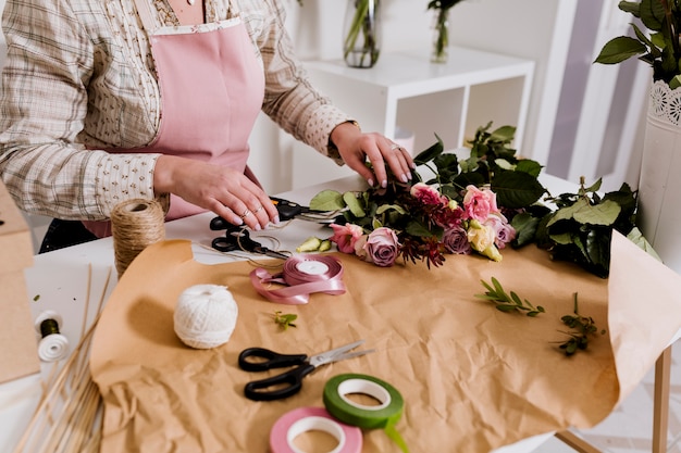 Crop florist preparing flowers