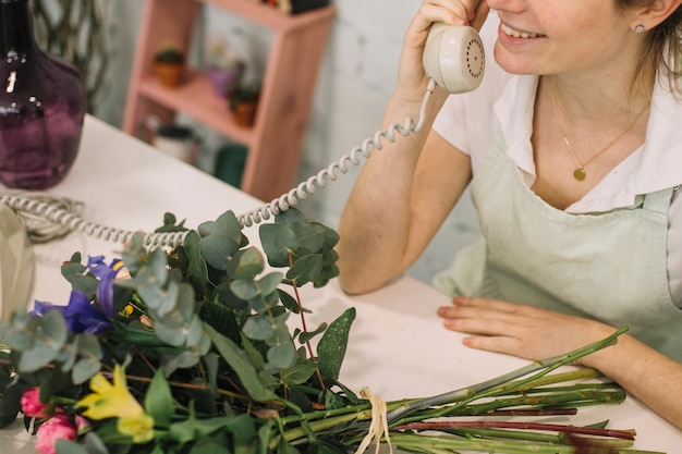 Crop florist speaking on hone