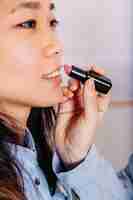 Free photo crop girl applying lipstick on friend