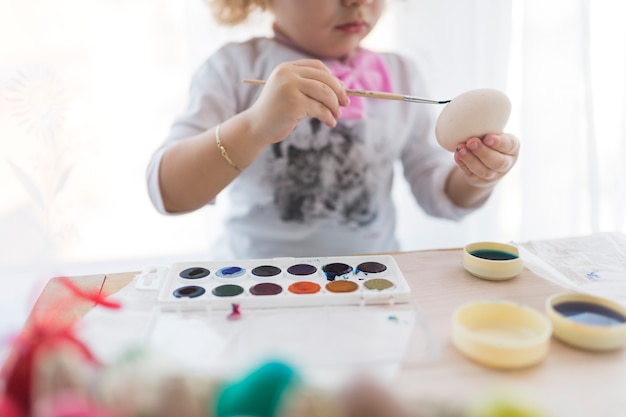 Crop girl coloring egg