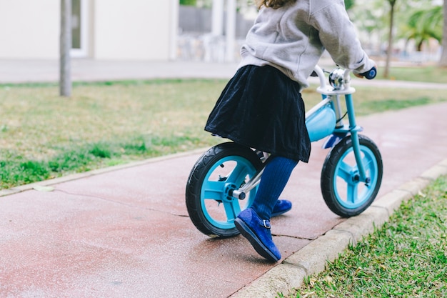 Crop girl riding bicycle