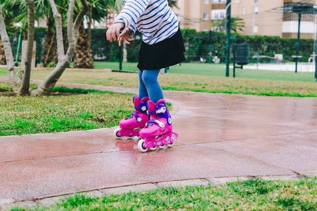 Free photo crop girl riding roller skates