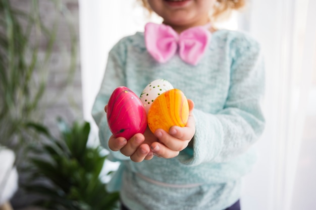 Foto gratuita ragazza che ritaglia mostrando le uova di pasqua