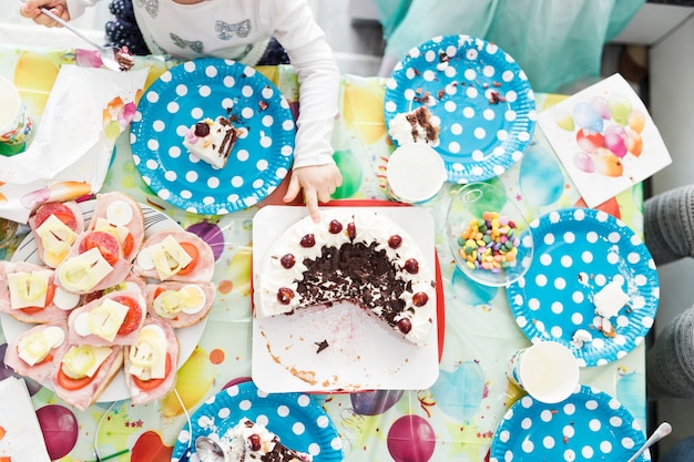 Crop girl touching cake