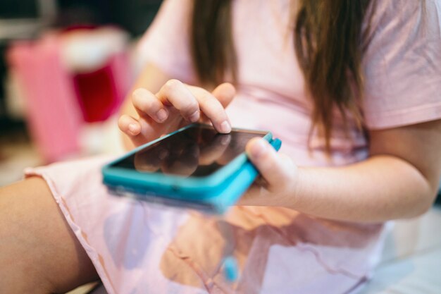 Crop girl using smartphone