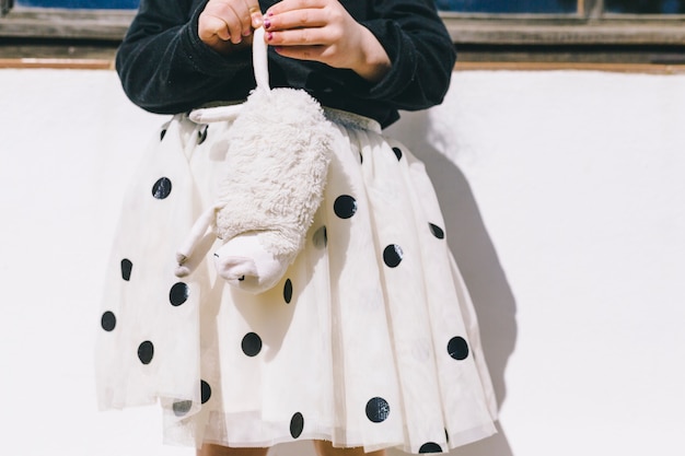 おもちゃの羊を持つ作物の女の子