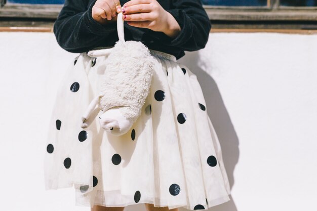 Crop girl with toy sheep