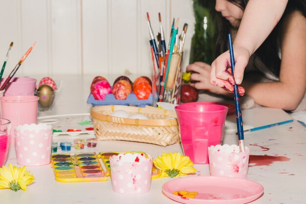 Crop girls decorating eggs