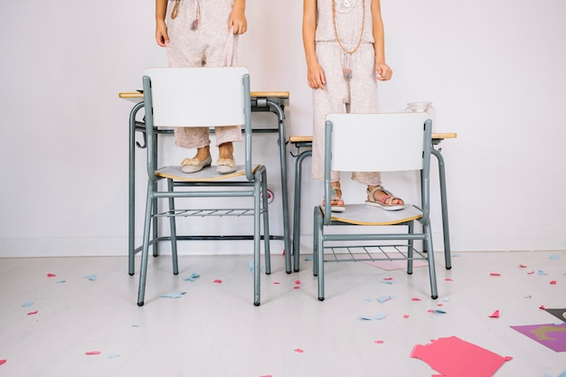 Free photo crop girls standing on chairs