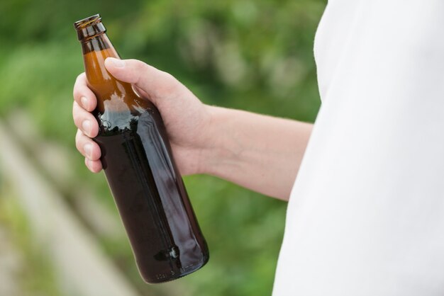 Crop guy with beer in nature