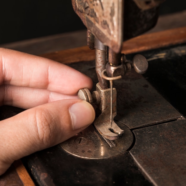 Foto gratuita ritaglia la mano che regola l'ago sulla macchina da cucire
