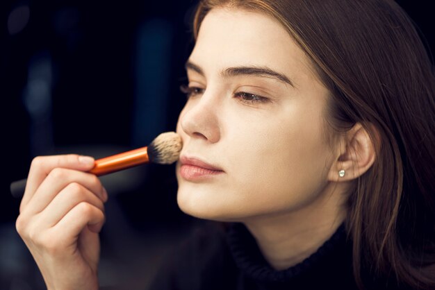 Crop hand applying powder on model