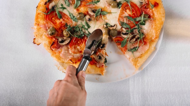 Free photo crop hand cutting pizza