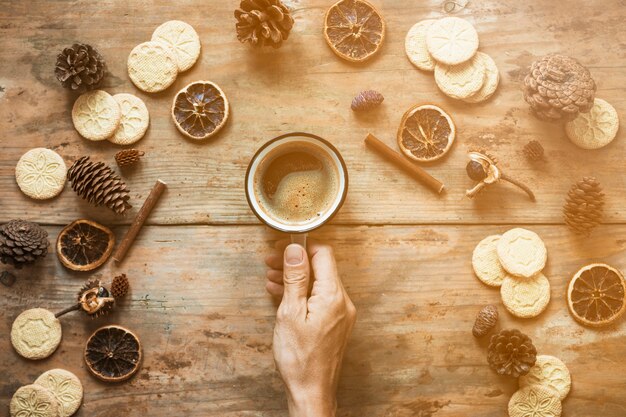 Crop hand holding coffee near spices