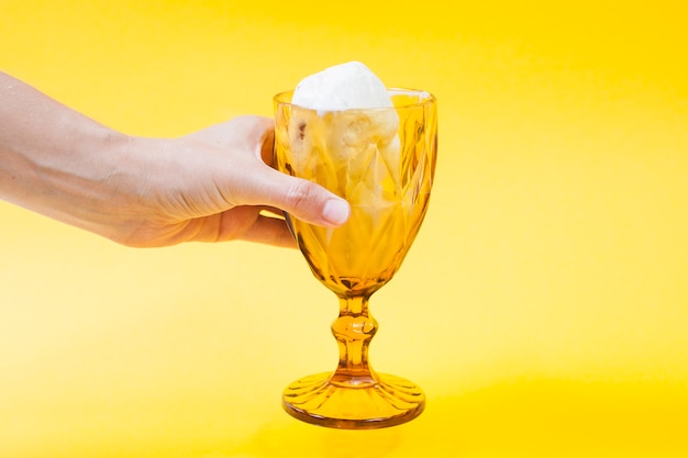 Crop hand holding cup of ice-cream