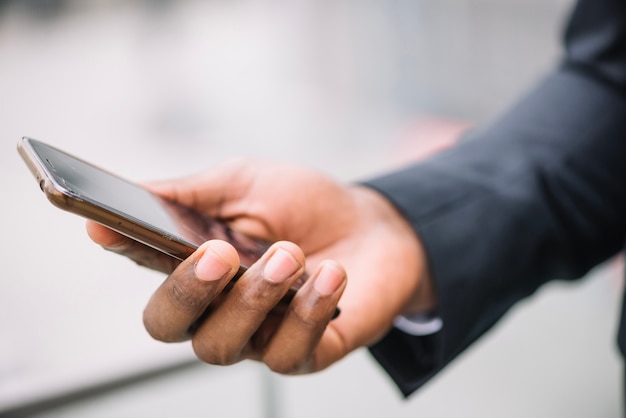 Crop hand holding smartphone