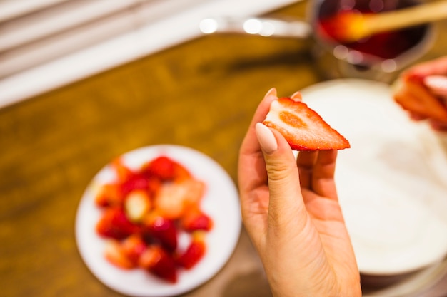 Crop hand holding strawberry