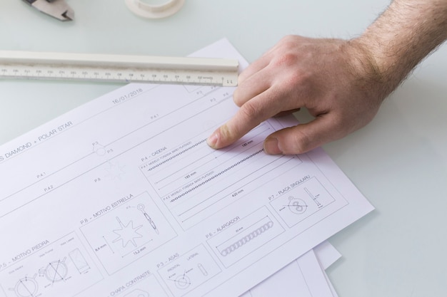 Crop hand pointing at data in document