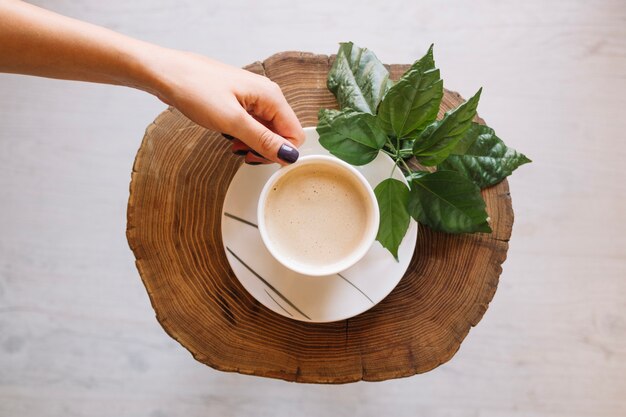 Foto gratuita ritaglia la mano mettendo il caffè su ыфгсук