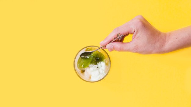 Crop hand taking ice-cream with topping